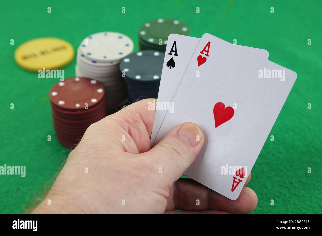 Hand hält ein Paar Asse mit Casino-Chips im Hintergrund Texas Holdem Poker besten Tasche Raketen amerikanischen Fluggesellschaften Stockfoto