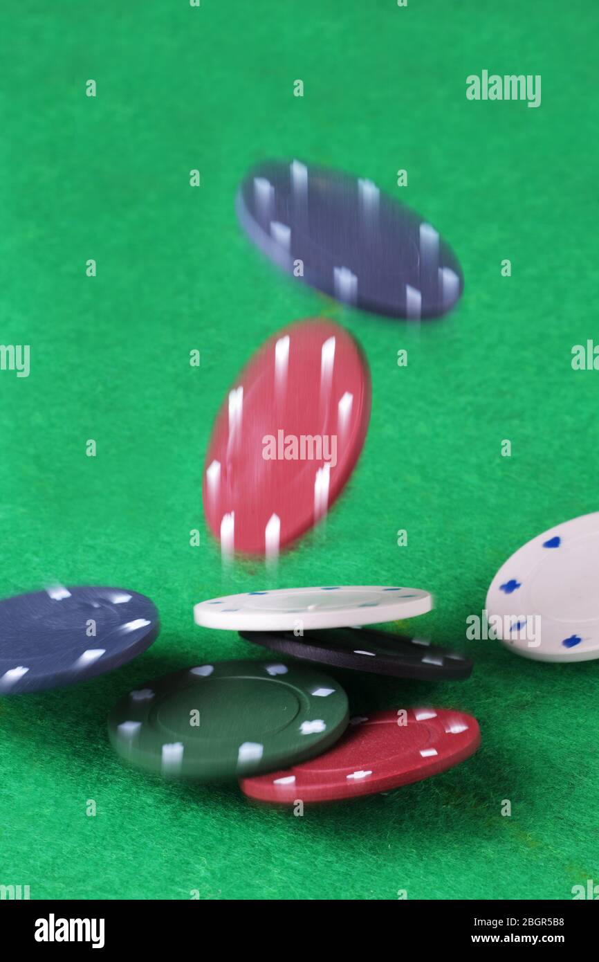 Den Topf spritzen. Casino Chips fallen auf einen Kartentisch. Stockfoto