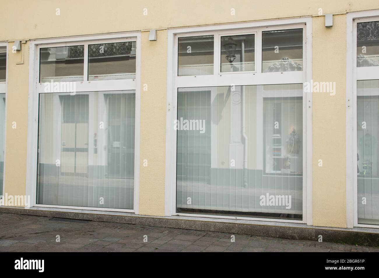 Fassade Geschäft Vorderwand, gelbes Licht mit großen Fenstern auf der Straße in der Stadt im Sommer sonnigen Tag. Stockfoto