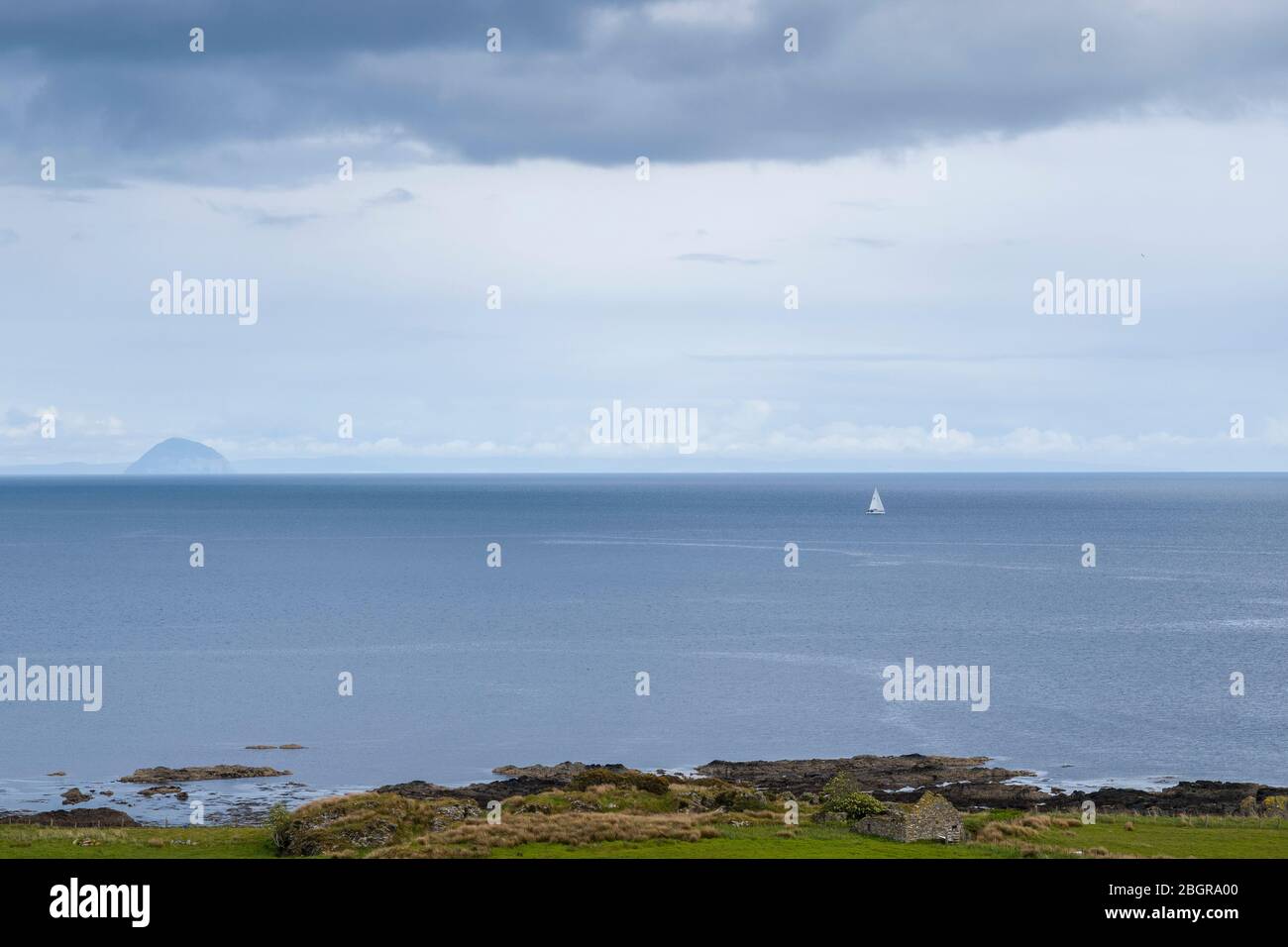 Einzelyacht in schottischer Landschaft mit im Hintergrund Ailsa Craig Insel im Firth of Clyde südlich der Isle of Arran, Schottland Stockfoto