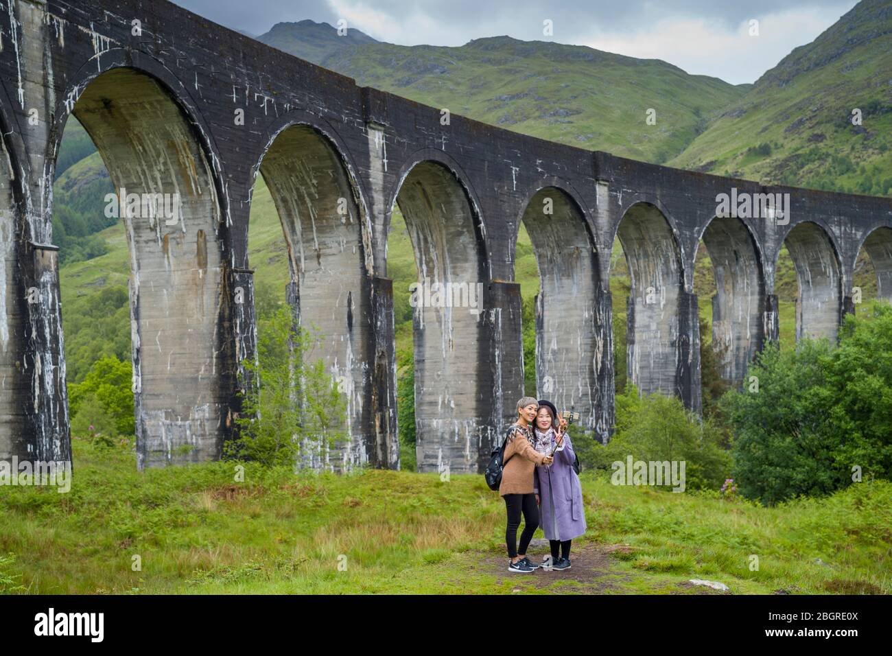 Touristen posieren für Selfies am berühmten Glenfinnan Viaduct Touristenort in den Highlands von Schottland Stockfoto