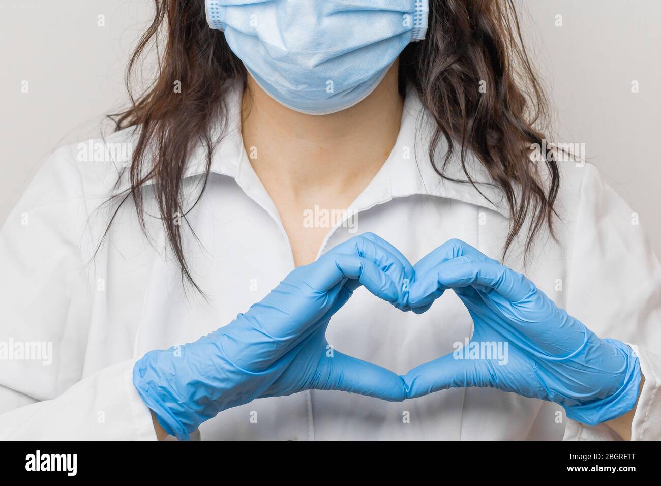 Stoppen Sie SARSCoV, Virus 2020, MERS-CoV, chinesisches Virus COVID-19. Damen Hand in blauen medizinischen Handschuhen zeigen Herz Zeichen. Konzept des Schutzes gegen HIV Stockfoto
