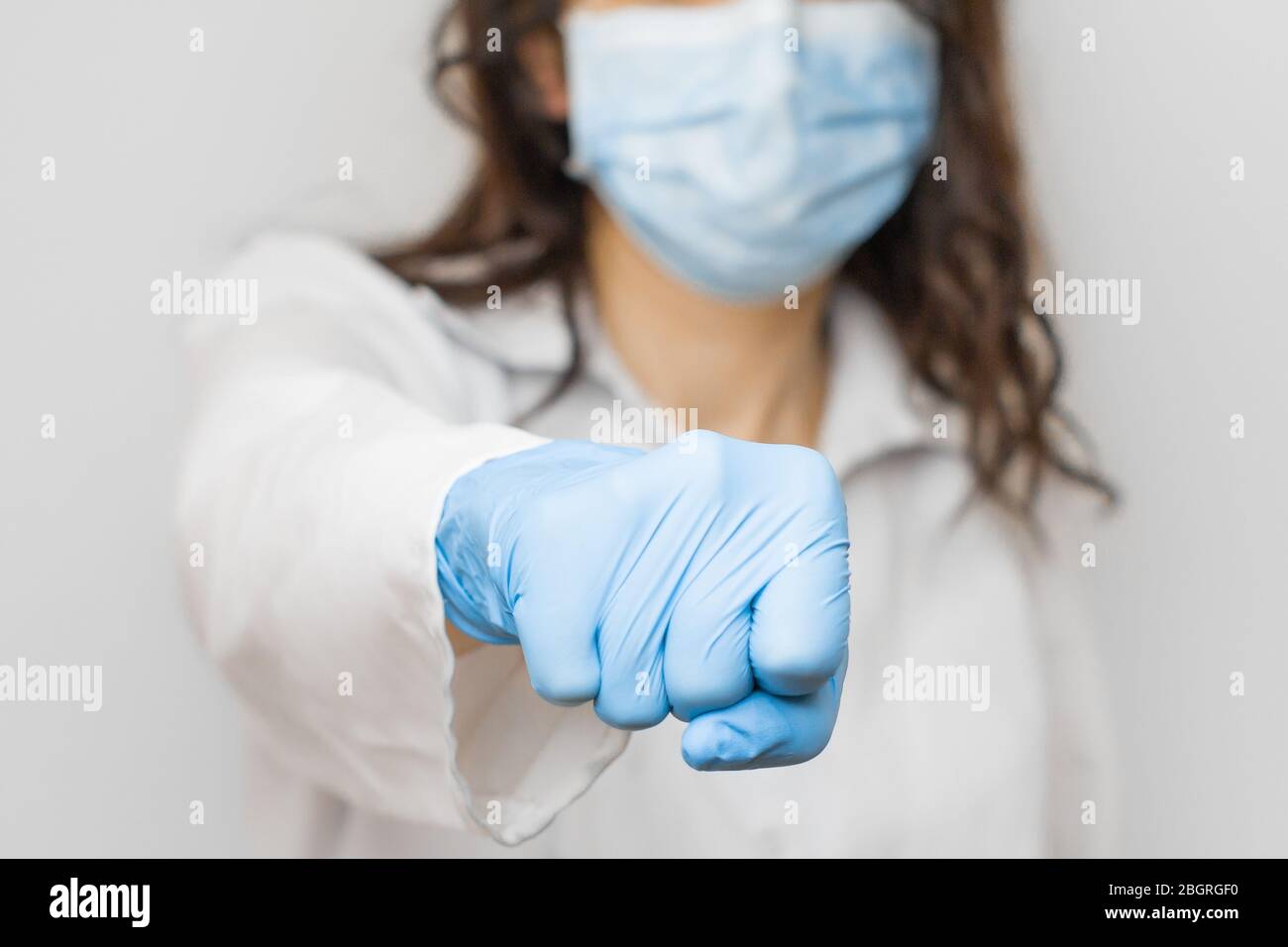 Stoppen Sie SARSCoV, Virus 2020, chinesisches Virus COVID-19. Damen Hand in blauen medizinischen Handschuhen zeigen Faust. Konzept des Schutzes gegen HIV. Doktor in blau Stockfoto