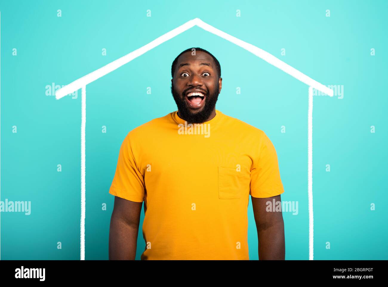 Der Mensch ist erstaunt, ein Haus gekauft zu haben. Cyanfarbener Hintergrund. Stockfoto