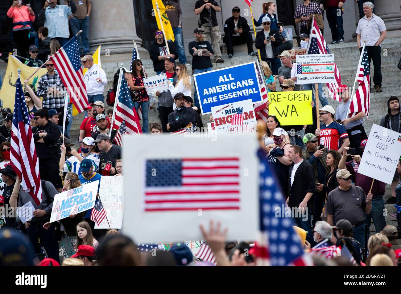 Die Menschen halten Zeichen, die Präsident Donald Trump unterstützen und fordern, dass der Staat Washington bei einem Protest gegen die Beschränkungen des Aufenthalts im eigenen Haus wieder eröffnet wird Stockfoto