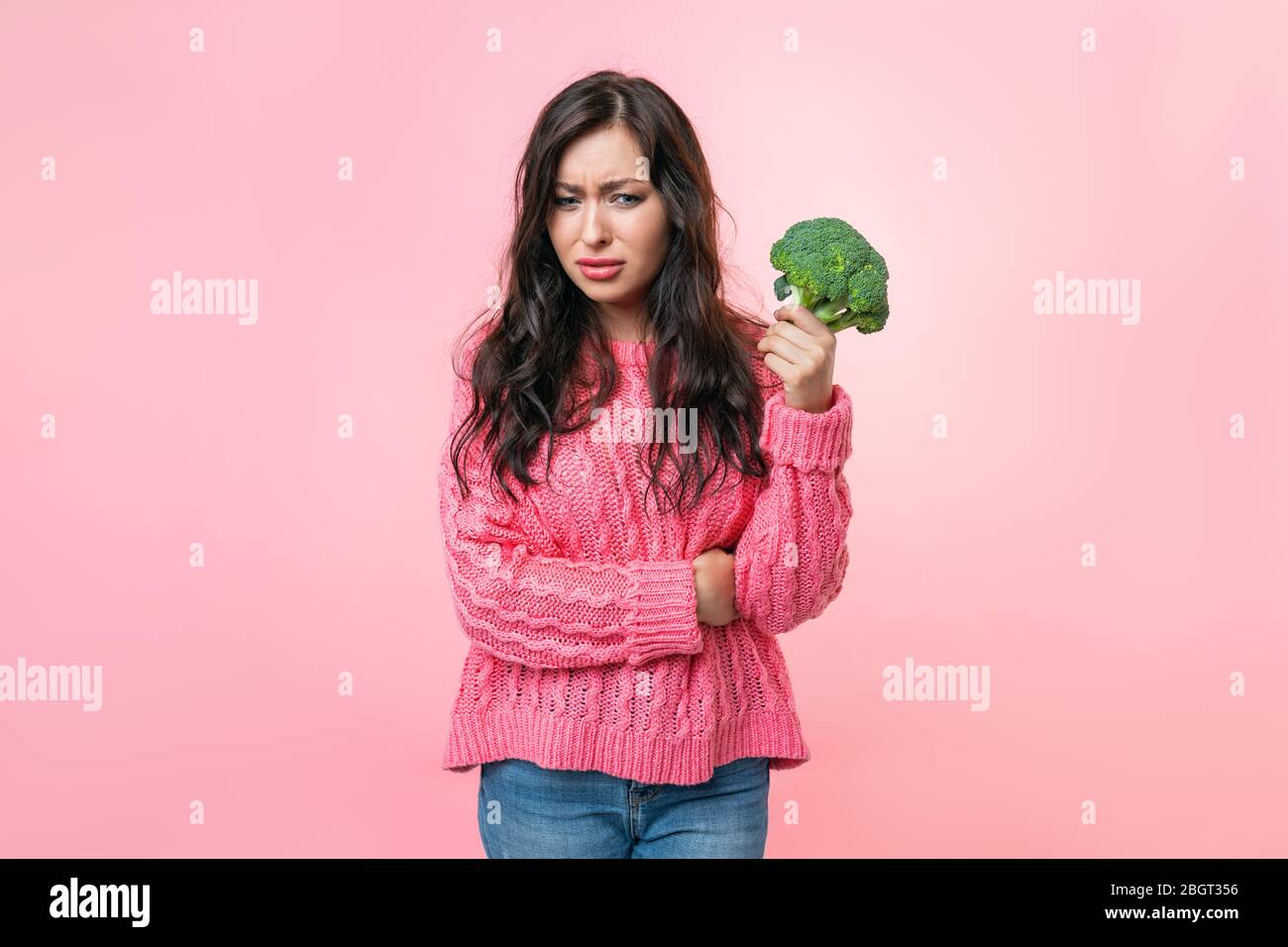 Eine junge Frau hält Brokkoli in der Hand. Das Mädchen war müde vom Nähren. Diät-Food-Konzept Stockfoto
