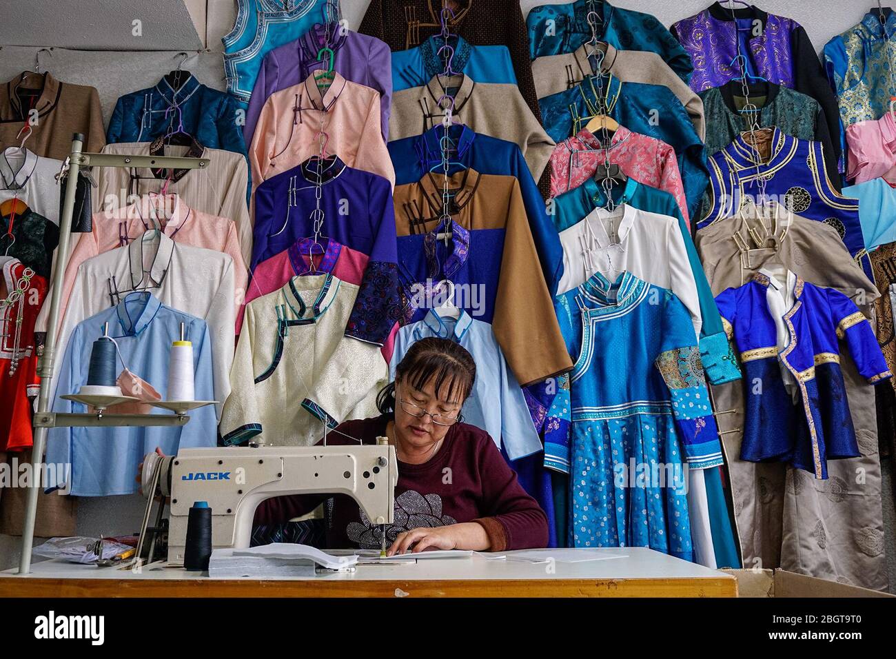Die Näherin Javzmaa Namsrai arbeitet vor einer Vielzahl mongolischer Mondneujahrkostüme, die sie während der alljährlichen Februarferien zu verkaufen gehofft hatte. Nach dem Verbot öffentlicher Versammlungen durch COVID-19, sagt Javzmaa, dass sie und ihre Tochter kämpfen. (Nansalmaa Oyunchieg, GPJ Mongolei) Stockfoto