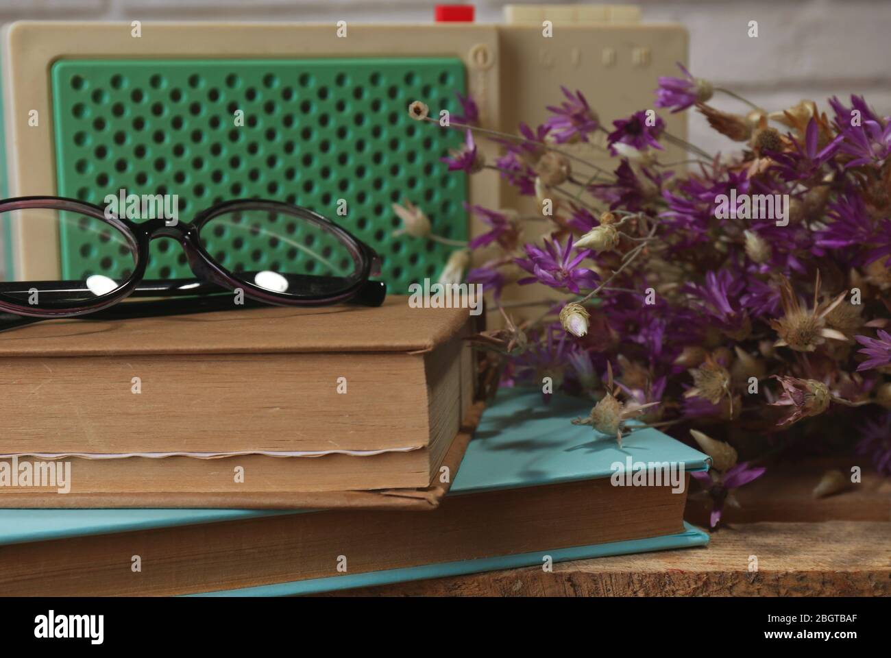 Retro-Radio, Buch und Gläser auf dem Tisch im Zimmer Stockfoto