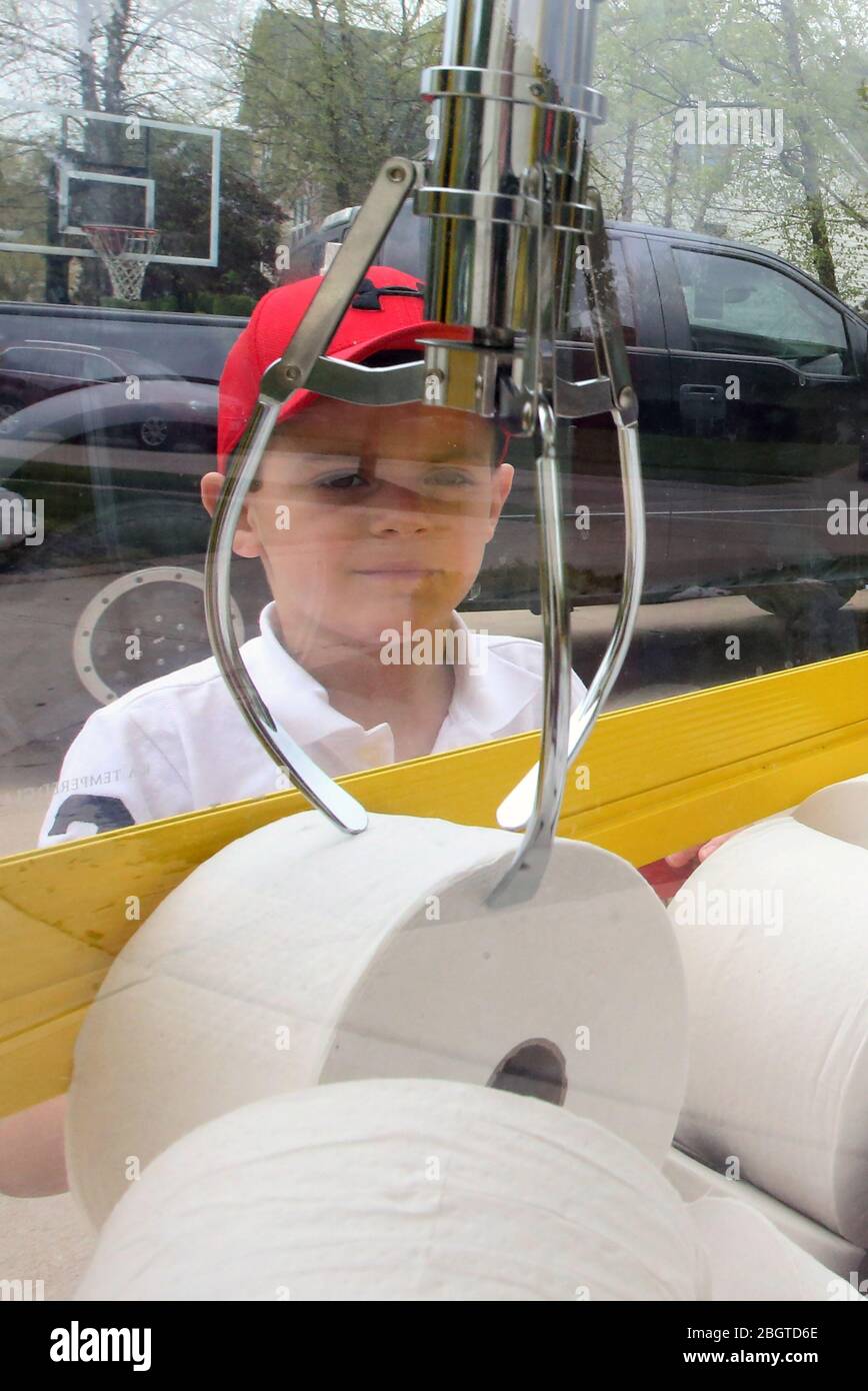 Chesterfield, Usa. April 2020. JJ Hofman (6) konzentriert sich darauf, am Mittwoch, den 22. April 2020, in Chesterfield, Missouri, eine Rolle Toilettenpapier mit seiner Klauenmaschine zu schnappen. Da Toilettenpapier knapp war, kaufte der Vater des Jungen James die Klauenmaschine, ersetzte ausgestopfte Tiere durch Toilettenpapier und berechnete den Nachbarn 5 Dollar für drei Versuche. Die Familie brachte 400 Dollar ein und trug damit zum Chesterfield, Missouri Polizeidezernat, für die mit dem Coronavirus verbundenen Kosten bei. Foto von Bill Greenblatt/UPI Quelle: UPI/Alamy Live News Stockfoto