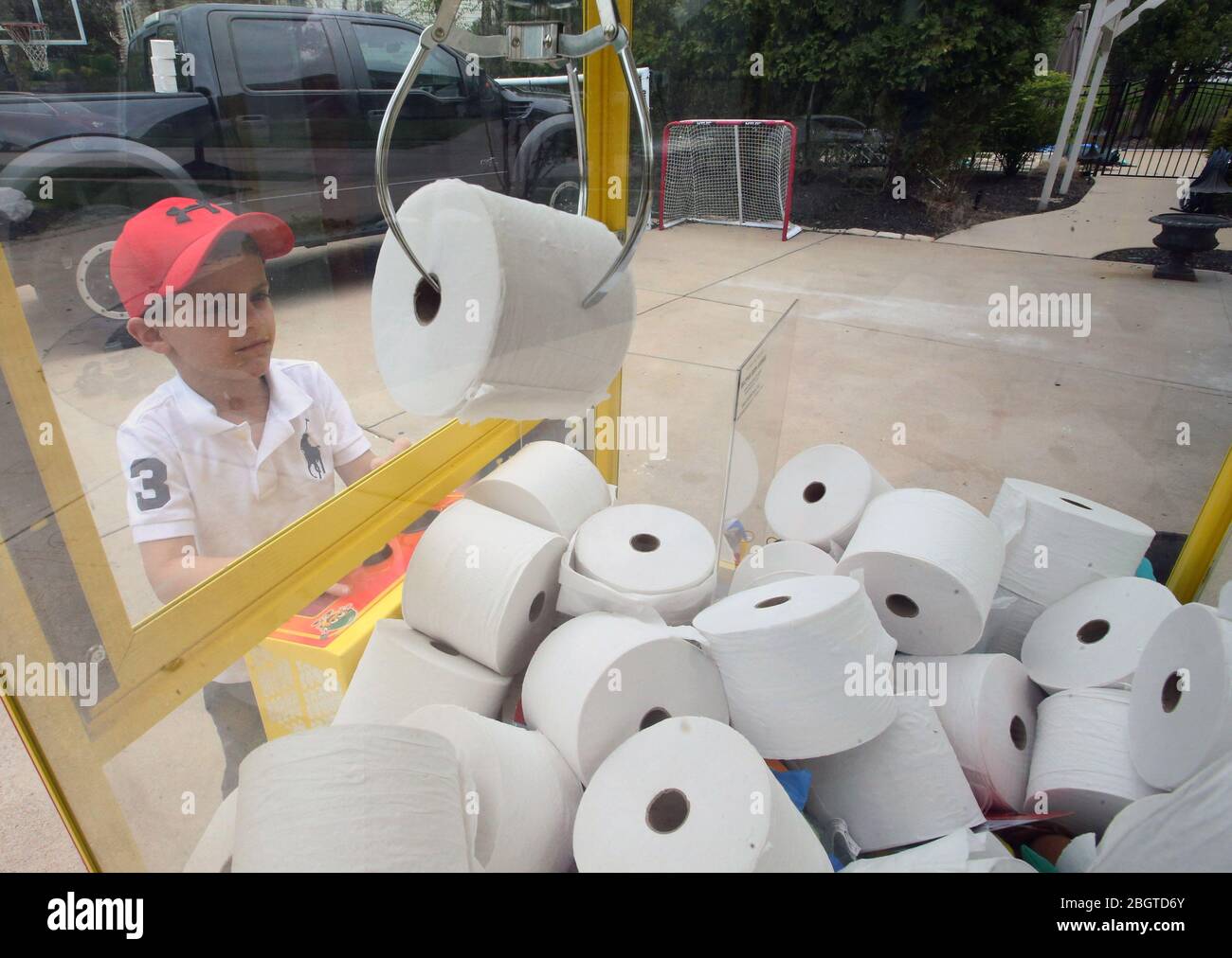 Chesterfield, Usa. April 2020. JJ Hofman (6) hat Glück, am Mittwoch, den 22. April 2020, eine Rolle Toilettenpapier mit seiner Klauenmaschine in Chesterfield, Missouri, zu schnappen. Da Toilettenpapier knapp war, kaufte der Vater des Jungen James die Klauenmaschine, ersetzte ausgestopfte Tiere durch Toilettenpapier und berechnete den Nachbarn 5 Dollar für drei Versuche. Die Familie brachte 400 Dollar ein und trug damit zum Chesterfield, Missouri Polizeidezernat, für die mit dem Coronavirus verbundenen Kosten bei. Foto von Bill Greenblatt/UPI Quelle: UPI/Alamy Live News Stockfoto