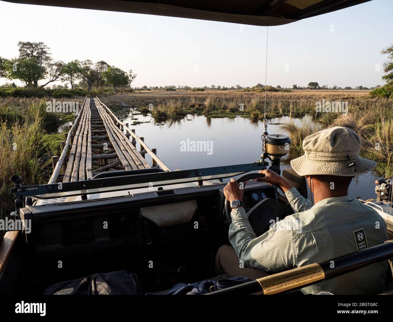 Wildfahrzeug über Holzbrücke im Okavango Delta, Botswana, Südafrika. Stockfoto