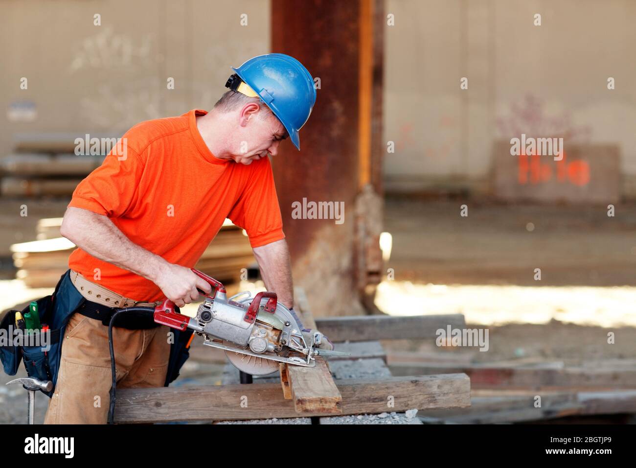 Männlicher Bauarbeiter, der Holz schneidet Stockfoto