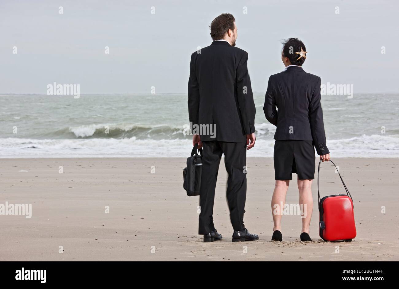Geschäftsleute stehen am leeren Strand Stockfoto