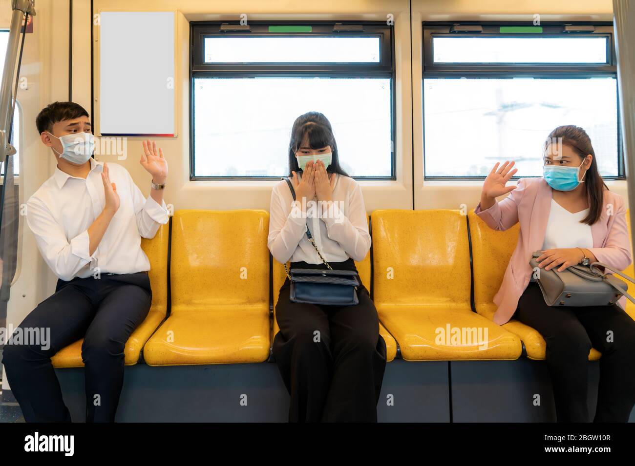 Asiatische Geschäftsfrau trägt Maske Niesen oder Husten in der U-Bahn und andere Menschen stoppen Schild Hand, um Abstand zu halten schützen vor COVID-19 Viren und pe Stockfoto