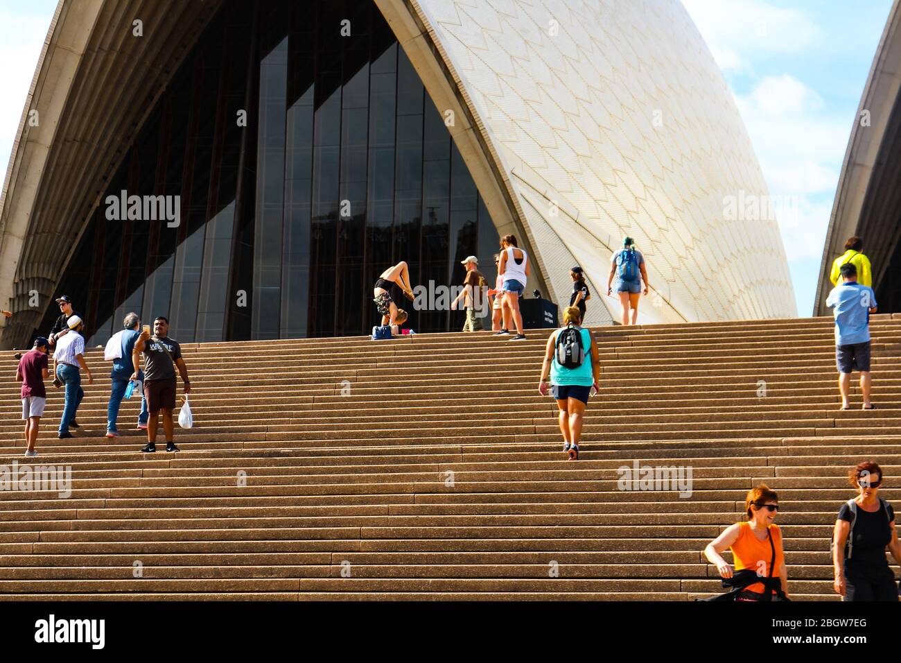Touristen posieren für Fotos im Sydney Opera House, eine Touristenin, die eine akrobatische Unterarmtribüne macht. Sydney, New South Wales, Australien. Stockfoto
