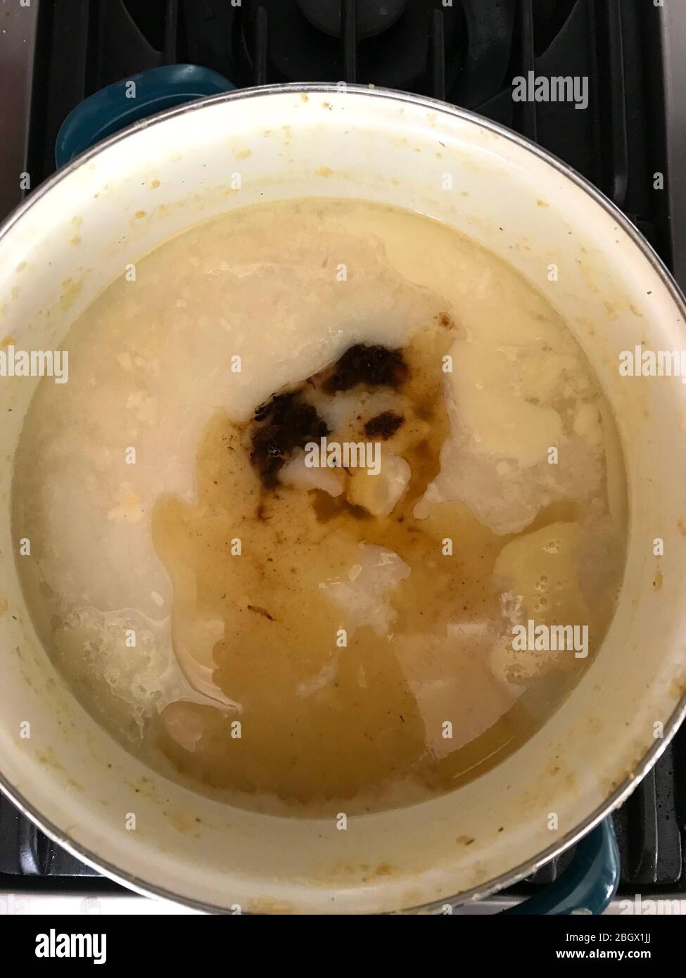 Das Gesicht einer Katze scheint in einem Topf Suppe auf dem Herd kochend erscheinen. Stockfoto