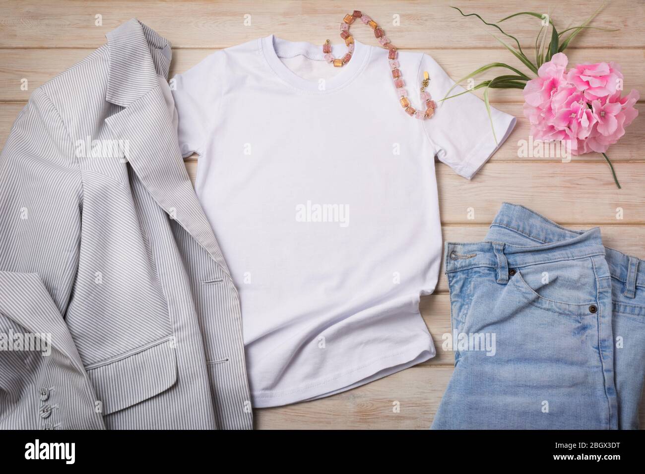 Weißes Damen-T-Shirt aus Baumwolle mit blauer Jeans, rosa Blume und grau gestreiftem Blazer. Design T-Shirt Vorlage, T-Print Präsentation Mock up Stockfoto