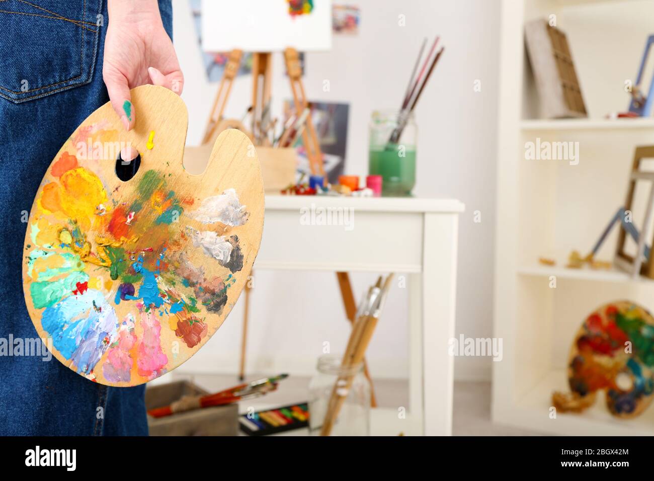 Künstler hält Palette mit Farben im Kunststudio Stockfoto