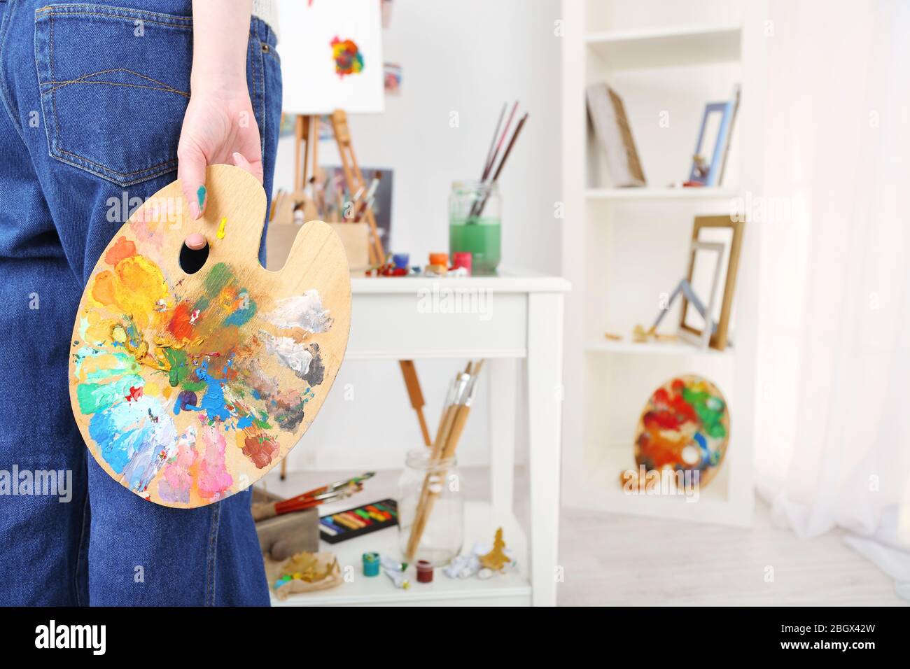 Künstler hält Palette mit Farben im Kunststudio Stockfoto