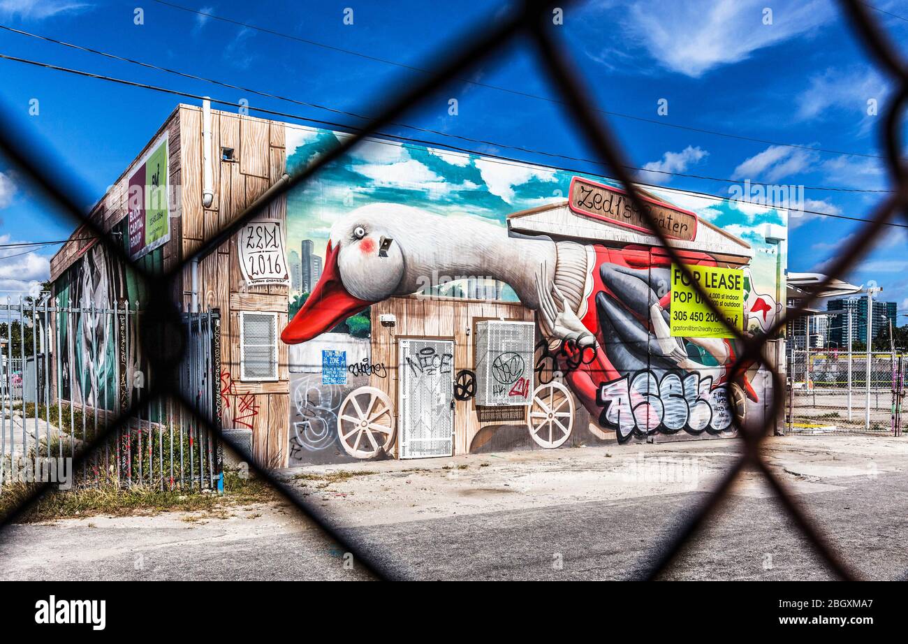 Ein heruntergekommenes Lager mit Graffiti-Dekoration, die durch gesehen wird und mit bunten Graffiti verziert ist, Wynwood Art District, Miami, Florida, USA. Stockfoto