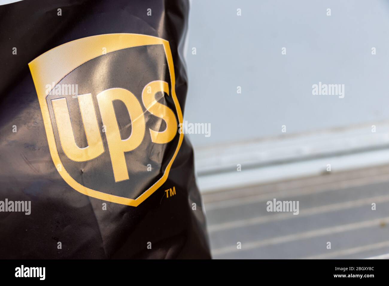 United Parcel Service (UPS) Logo auf einem Paket, das an eine Haustür geliefert wird. Stockfoto