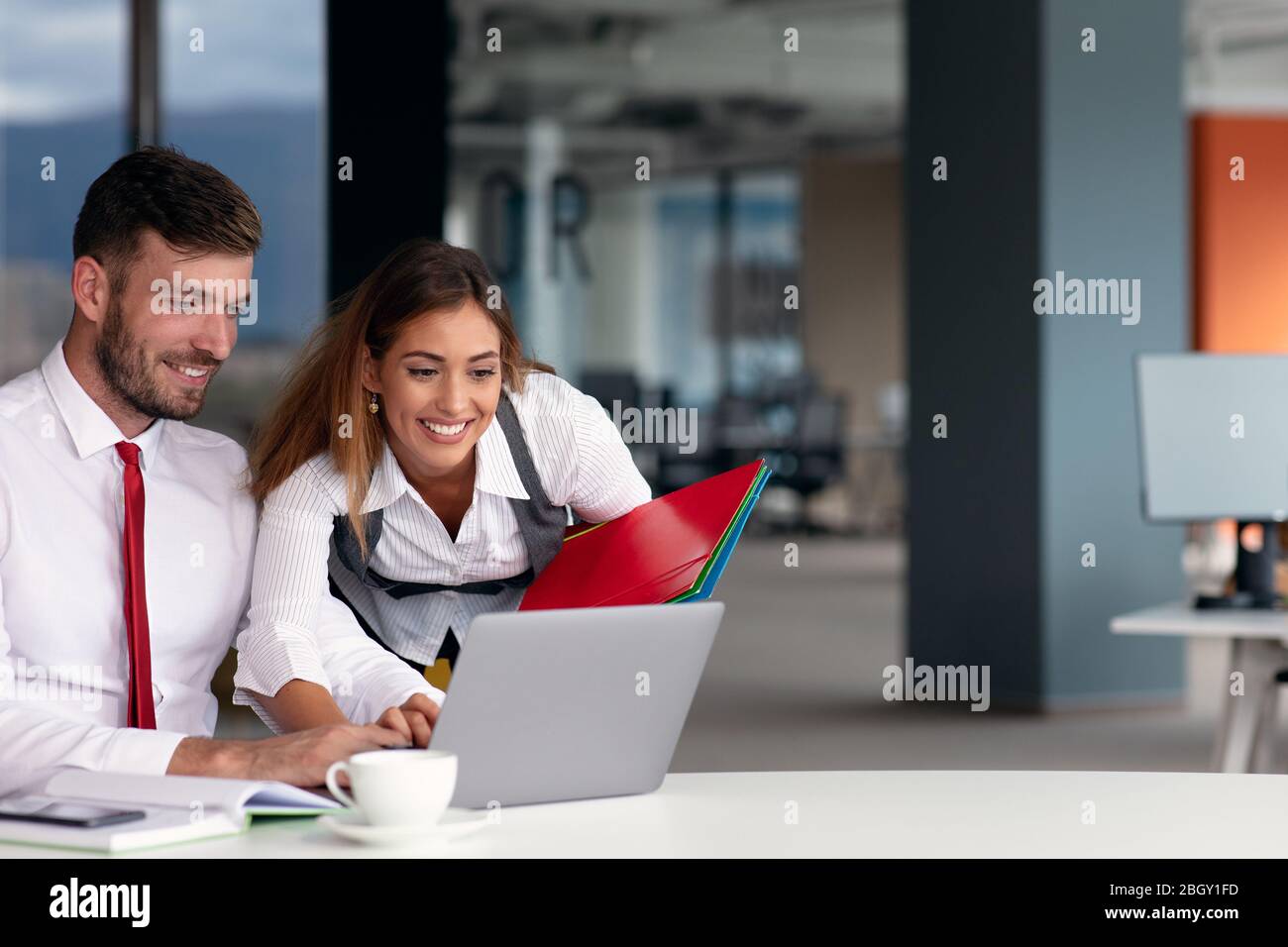 Junge Geschäftsleute arbeiten zusammen am Computer Stockfoto