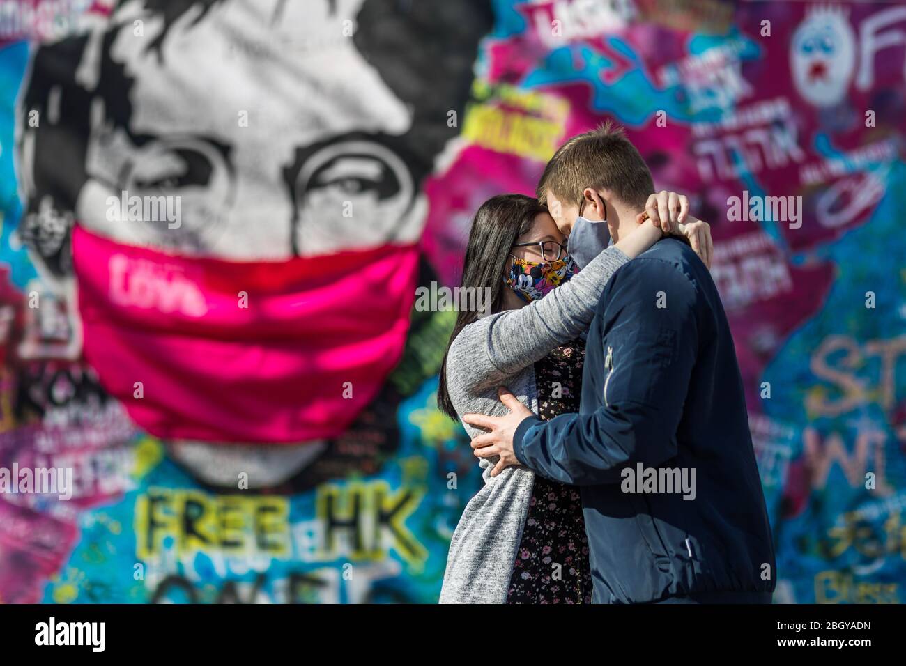 Zwei Liebende stehen während der Krise von 19 vor der John Lennon-Mauer in Prag mit Gesichtsmasken. Prag, Tschechische republik Stockfoto