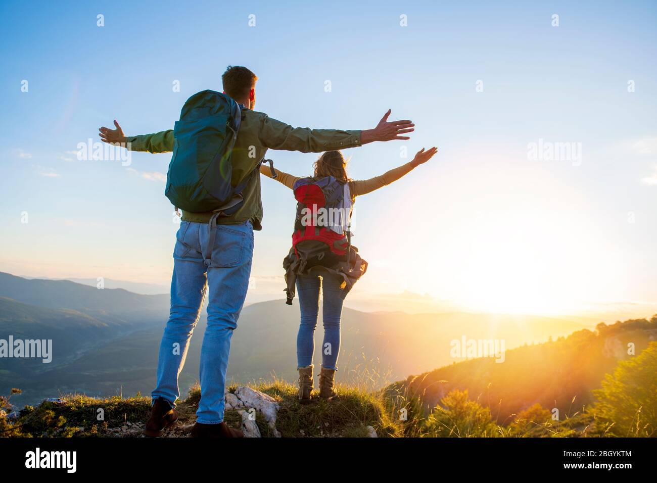 Paar mit erhobenen Armen halten die Hände und Blick auf den Sonnenuntergang Stockfoto