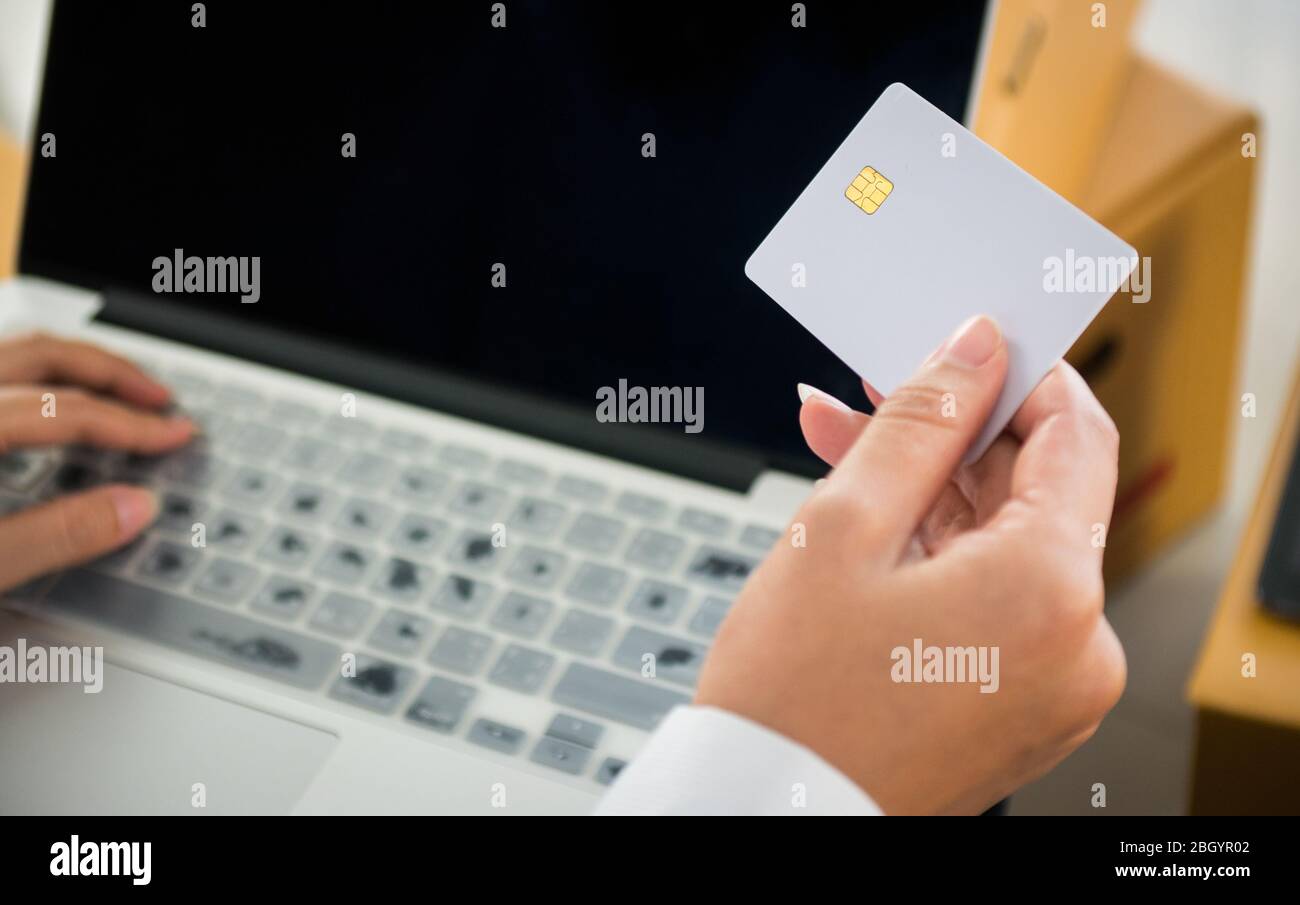 Start-up-Besitzer Kleinunternehmen halten Kreditkarte zur Hand, um Finanztransaktionen online mit vielen Paket am Arbeitsplatz in Online SE zu machen Stockfoto