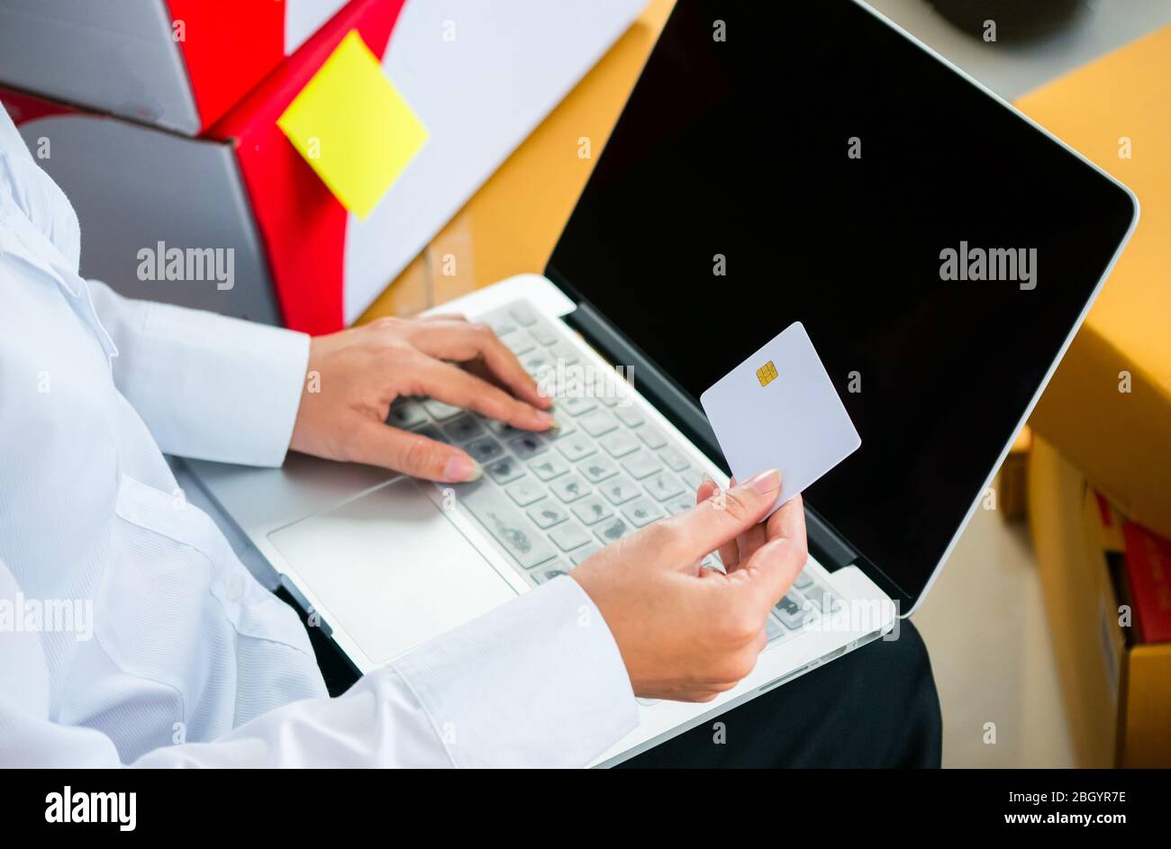 Start-up-Besitzer Kleinunternehmen halten Kreditkarte zur Hand, um Finanztransaktionen online mit vielen Paket am Arbeitsplatz in Online SE zu machen Stockfoto