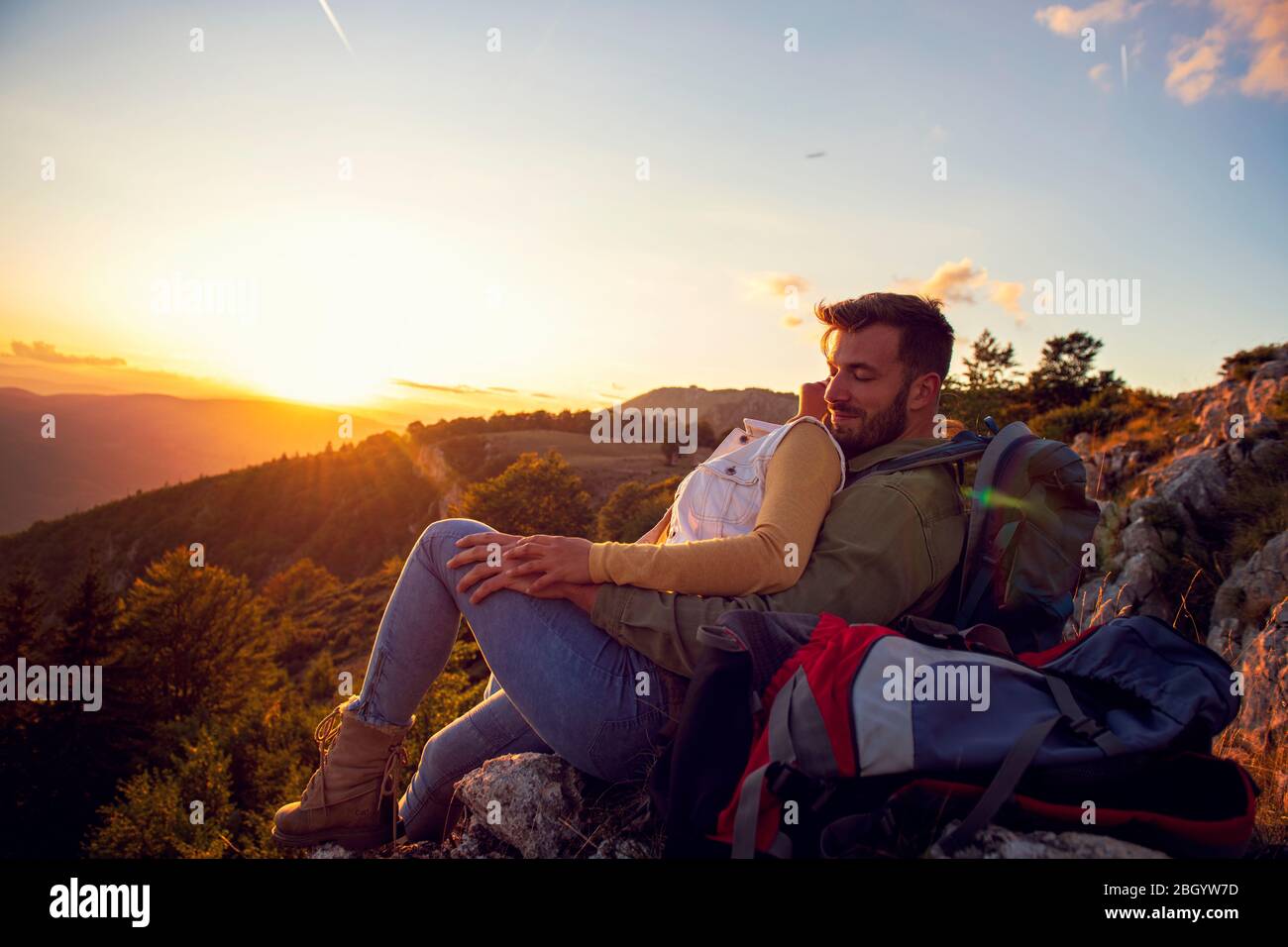 Paar Mann und Frau sitzen auf Klippe genießen Berge und Wolken Landschaft Liebe und Reisen glücklich Emotionen Lifestyle-Konzept. Stockfoto