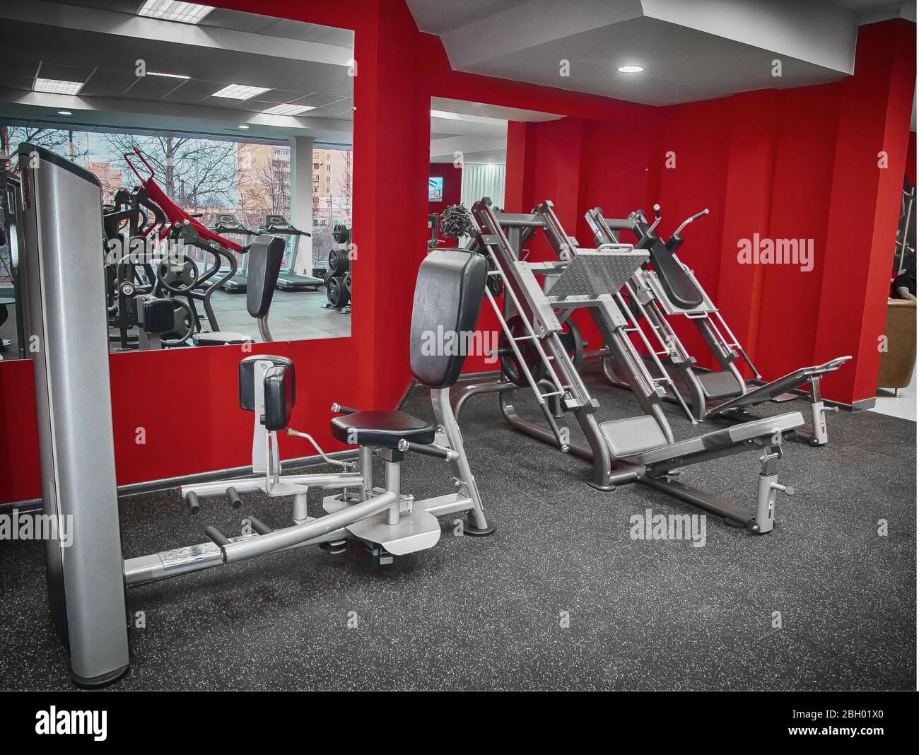 Modernes rotes Fitnessstudio mit Fitnessgeräten Stockfoto