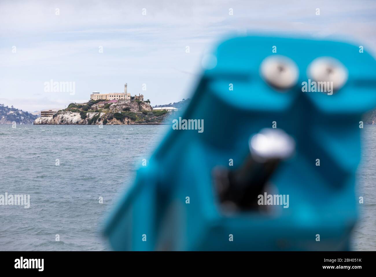Nahaufnahme der Insel Alcatraz in der Bucht von San Francisco, mit einem blauen Münzfernglas im Vordergrund Stockfoto