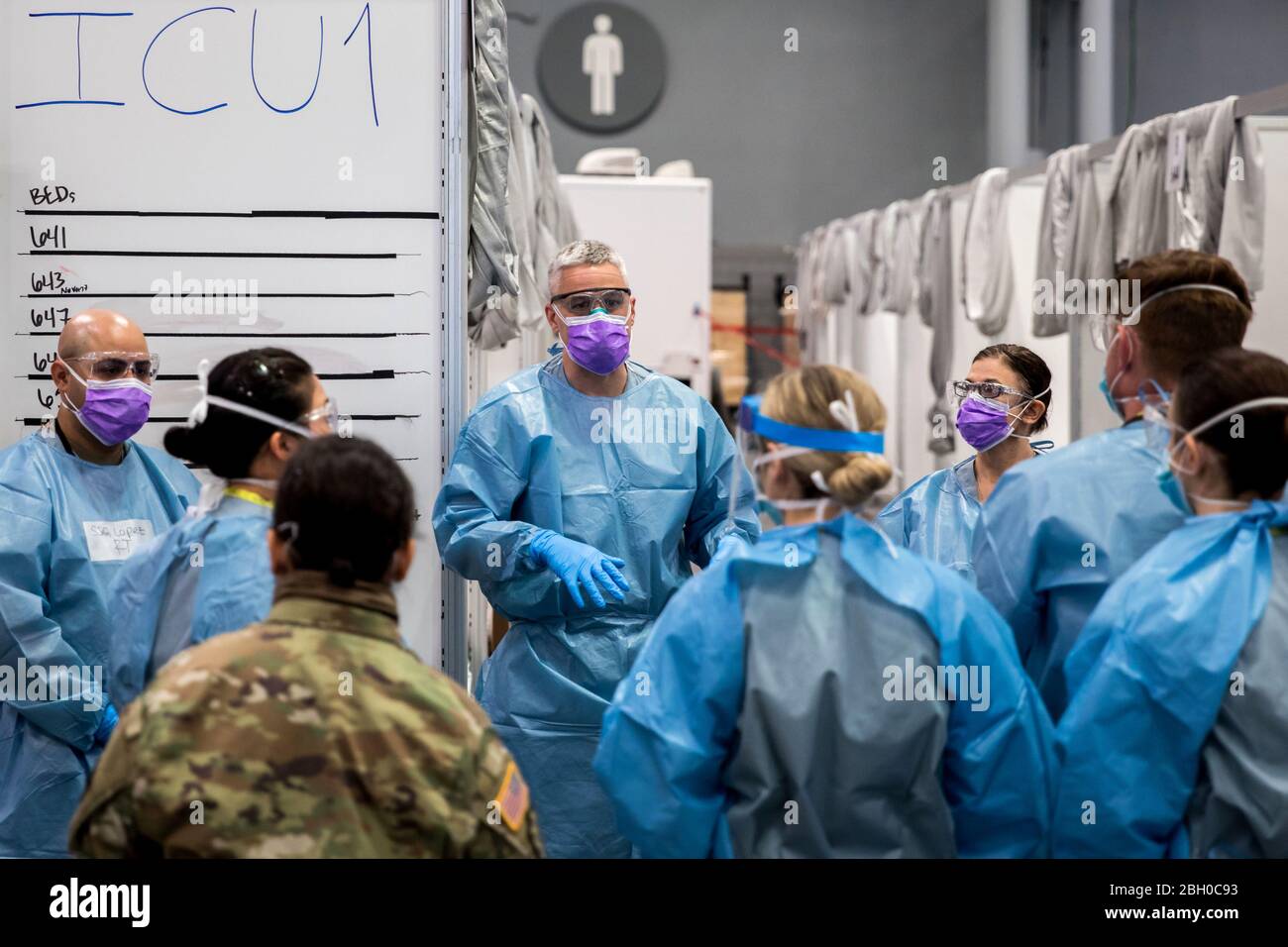 Army Maj. Sean Shirley hält ein Treffen mit Mitarbeitern in der Intensivstation der Javits New York Medical Station (JNYMS) ab. Die Einrichtung, die seit dem 30. März 2020 für nicht-COVID-19-Patienten in Betrieb ist und sich um sie kümmert, begann am 3. April mit der medizinischen Versorgung von Patienten mit dem Virus. Stockfoto