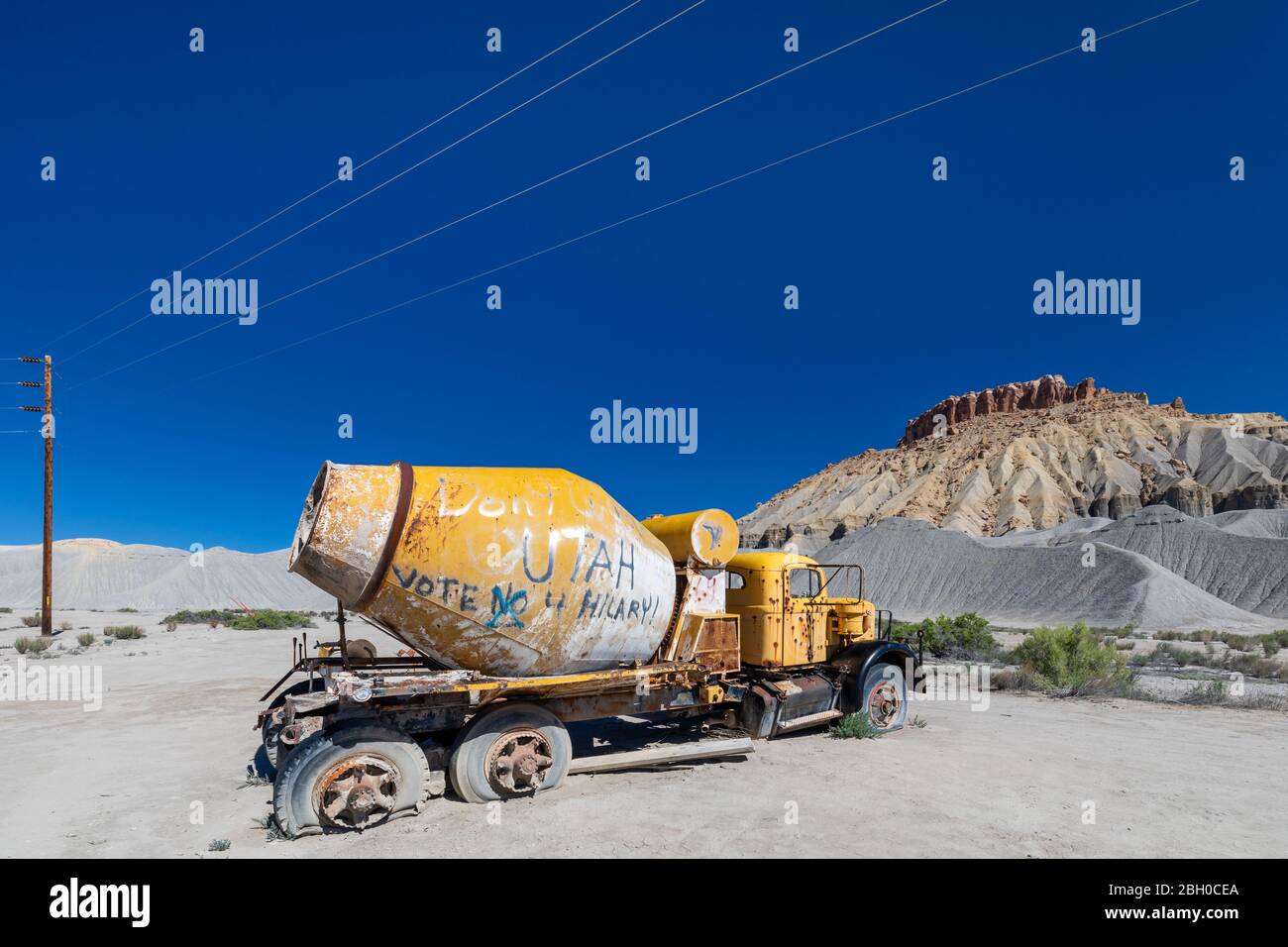 Ein alter und rostiger Zementmischer liegt verlassen in einem Kiesbruch in Utah, unter einem blauen Sommerhimmel Stockfoto