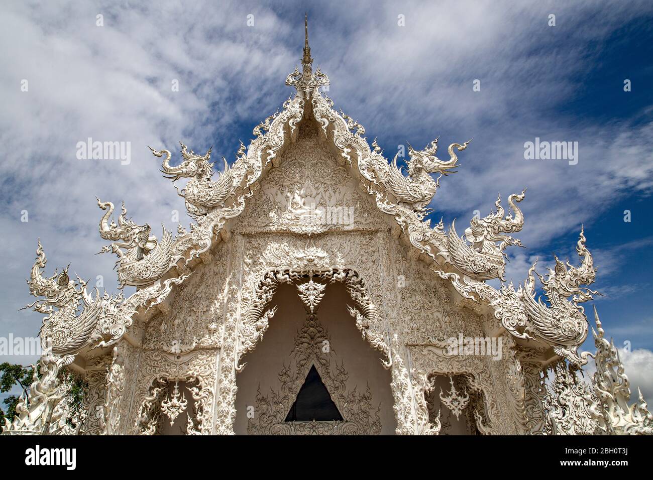 Weißer Tempel, bekannt als Wat Rong Khun mit seiner Spiegelung im Wasser, in Chiang Rai, Thailand. Stockfoto