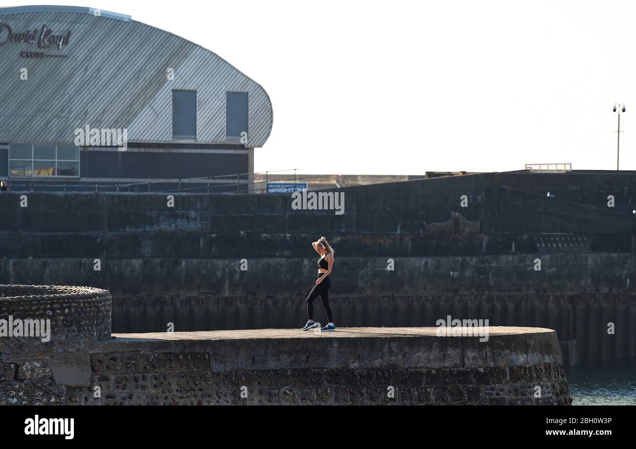 Brighton UK 23. April 2020 - EINE junge Frau, die an einem schönen heißen sonnigen Tag während der Sperrbeschränkungen während der Coronavirus COVID-19 Pandemie-Krise in der Nähe von Brighton Marina Sport übt. Die Temperaturen werden voraussichtlich 25 Grad in einigen Teilen des Südostens heute zu erreichen. Quelle: Simon Dack / Alamy Live News Stockfoto
