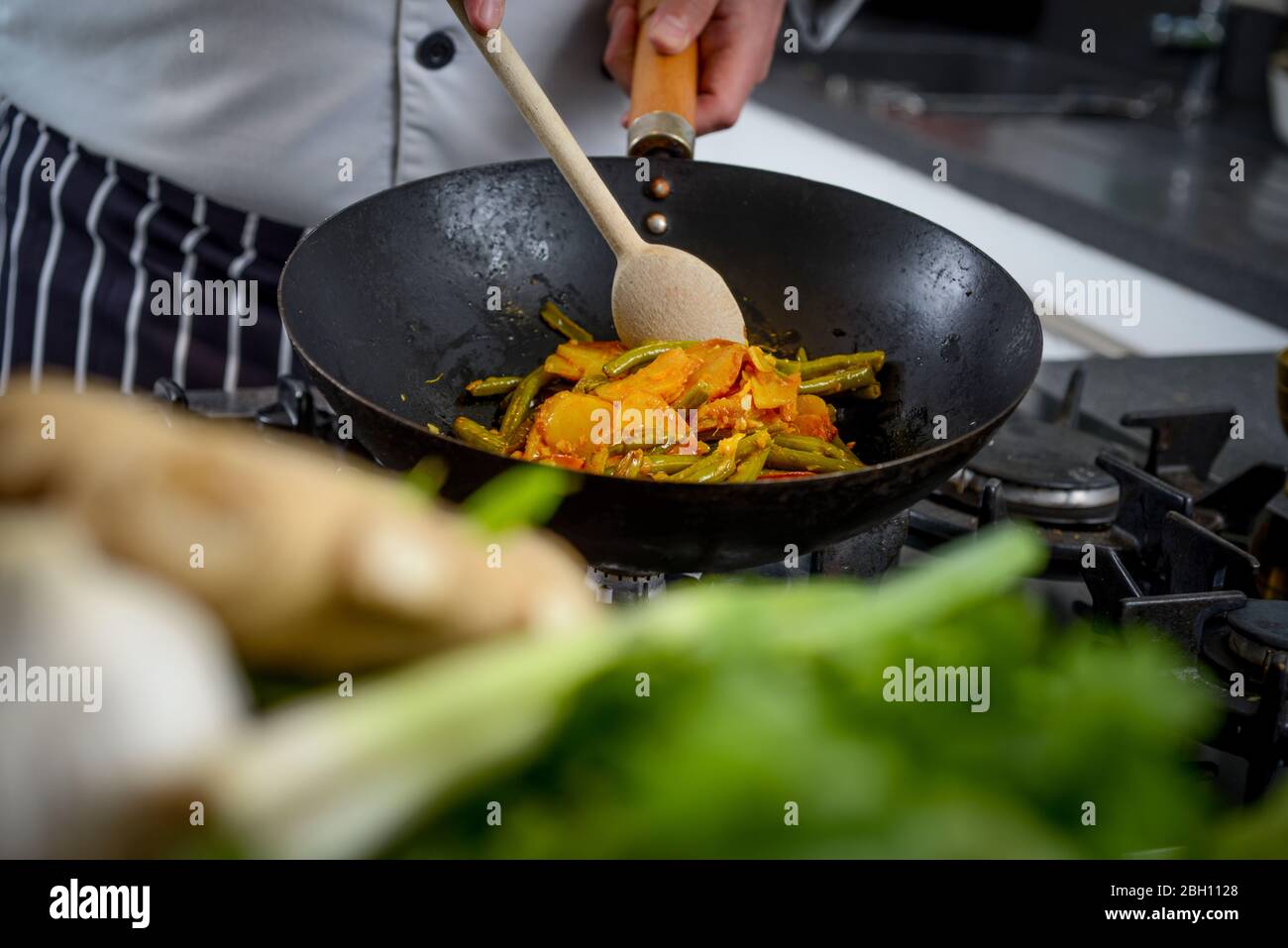 Ein Koch bereitet nepalesische Gerichte in einer britischen Küche zu. Stockfoto