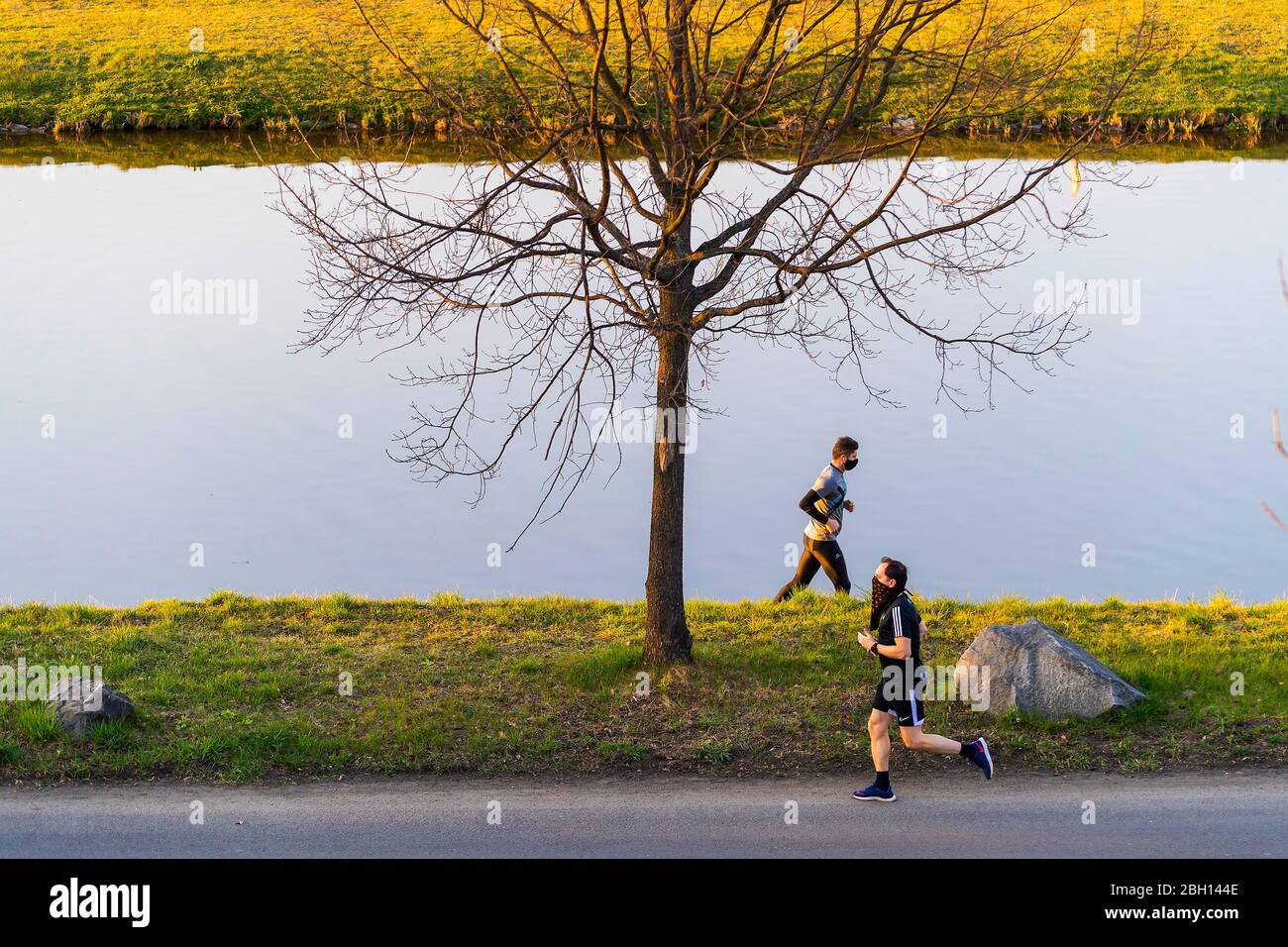 Läufer mit OP-Maske am Fluss laufen Stockfoto