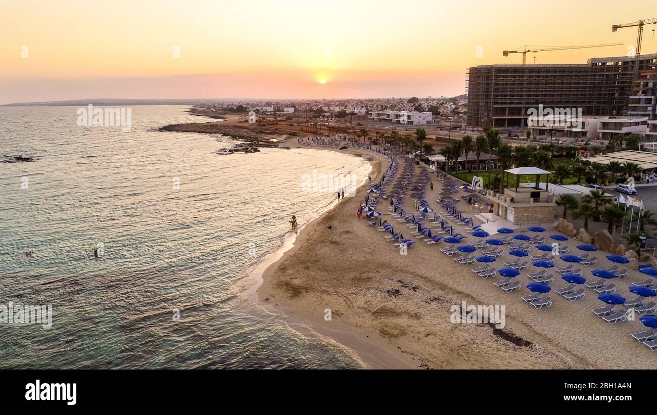 Blick auf den Sonnenuntergang an der Küste und den markanten Strand von Agia Thekla, Ayia Napa, Famagusta, Zypern von oben. Blick auf die Skyline von Vögeln auf Touristen Stockfoto