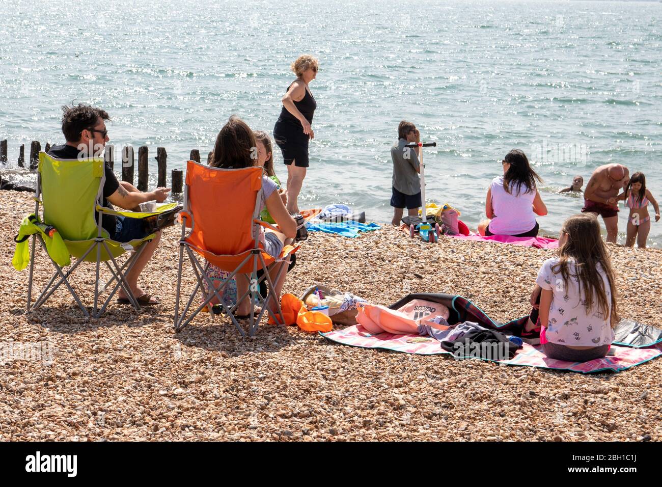 Familien an einem britischen Kiesstrand im Sommer ein typisches Britische Kiesstrand-Szene Stockfoto