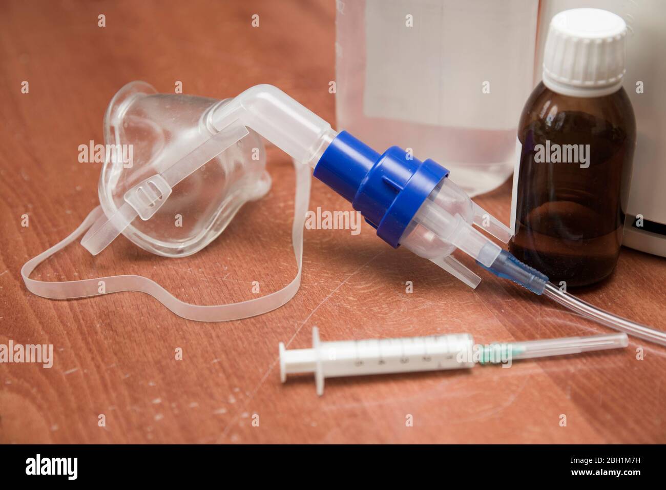 Medizinische Geräte zum Einatmen mit Atemschutzmaske, Vernebler auf dem Holztisch Stockfoto