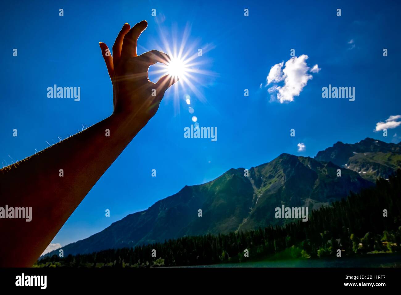 Sonnenstern in der Hand mit blauem Himmel Stockfoto