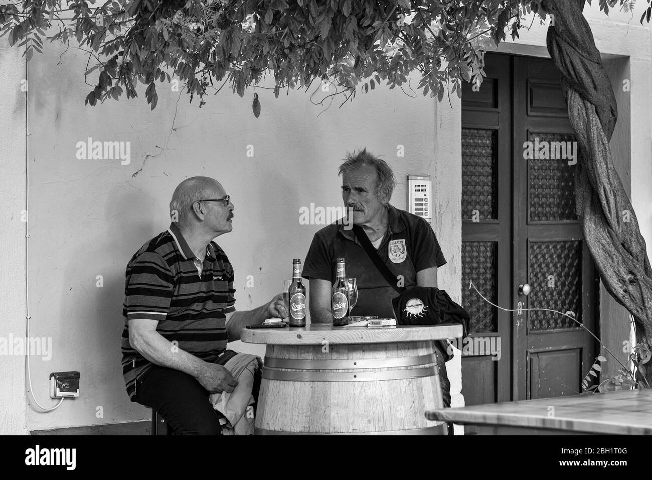 Zwei Männer bei einem Bier: Bar Miramar auf Carpacciov trg, Altstadt, Koper, Slowenien. Schwarz-weiße Version Stockfoto