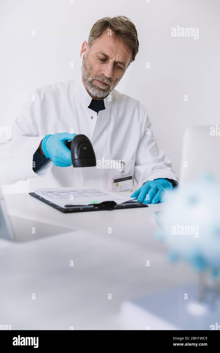 Wissenschaftler scannen Formulare am Schreibtisch Stockfoto