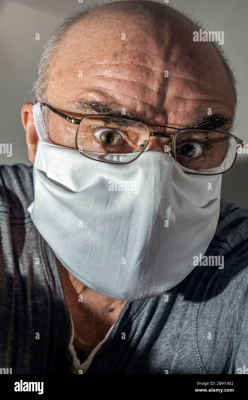 Porträt eines älteren Mannes mit OP-Maske in Panik Stockfoto