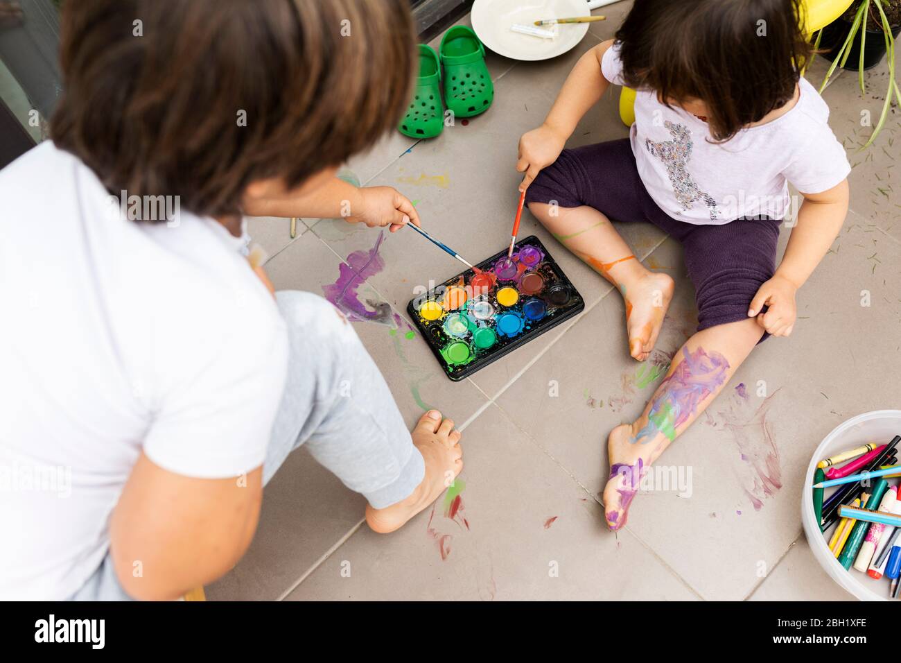 Kleine Mädchen und Jungen Malerei mit Aquarellen Stockfoto
