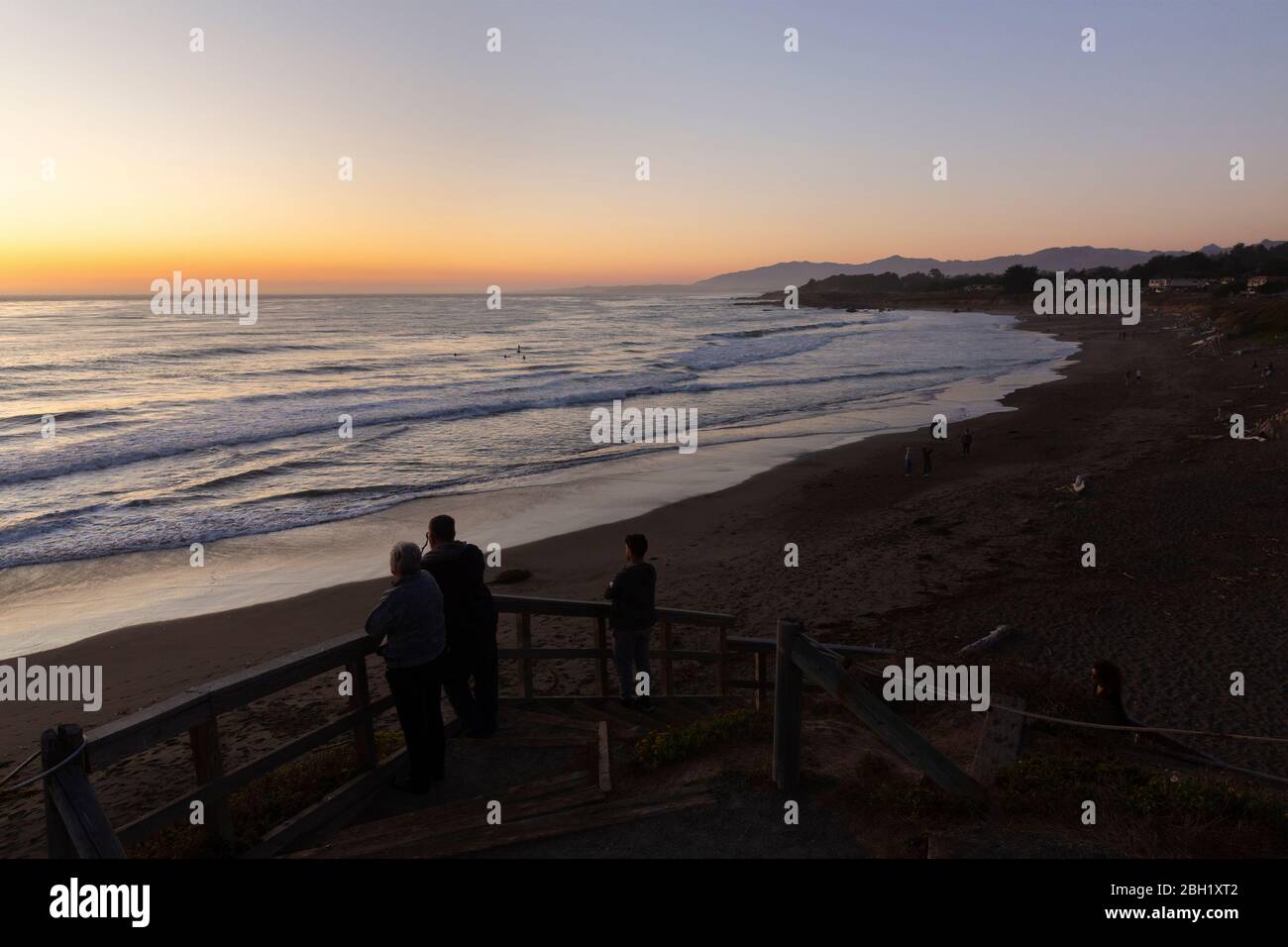CAMBRIA, VEREINIGTE STAATEN - SEPTEMBER 21, 2019 : Sonnenuntergang am Moonstone Beach an der kalifornischen Küste mit Menschen beobachten die Abend Surfer. Stockfoto
