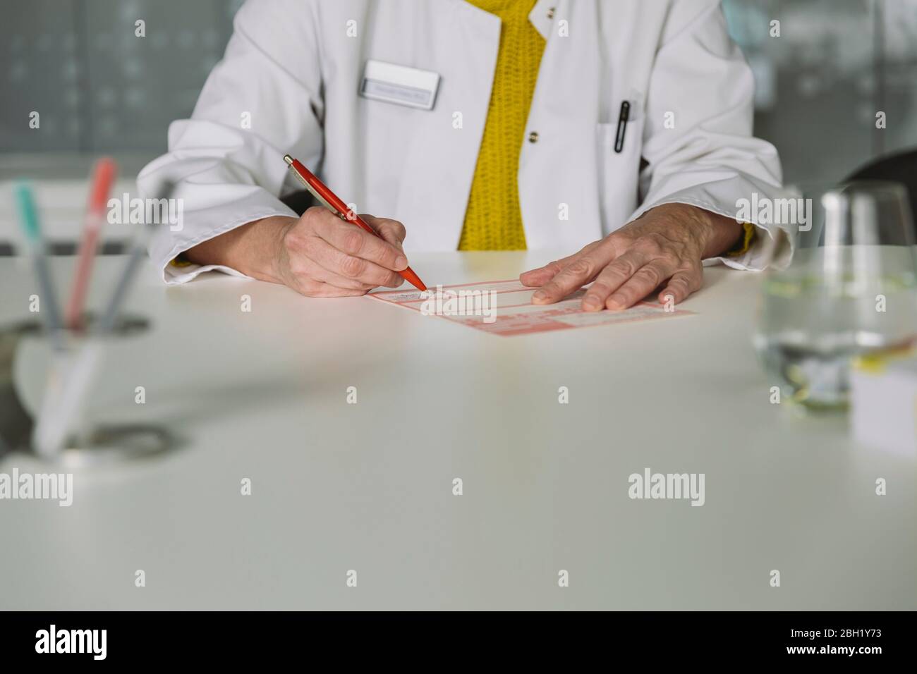 Arzt an der Rezeption, der die Verordnung ausfüllt Stockfoto