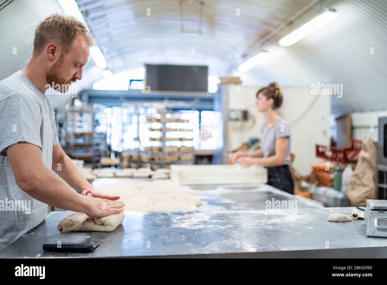 Mann und Frau bereiten Brot in der Bäckerei Stockfoto